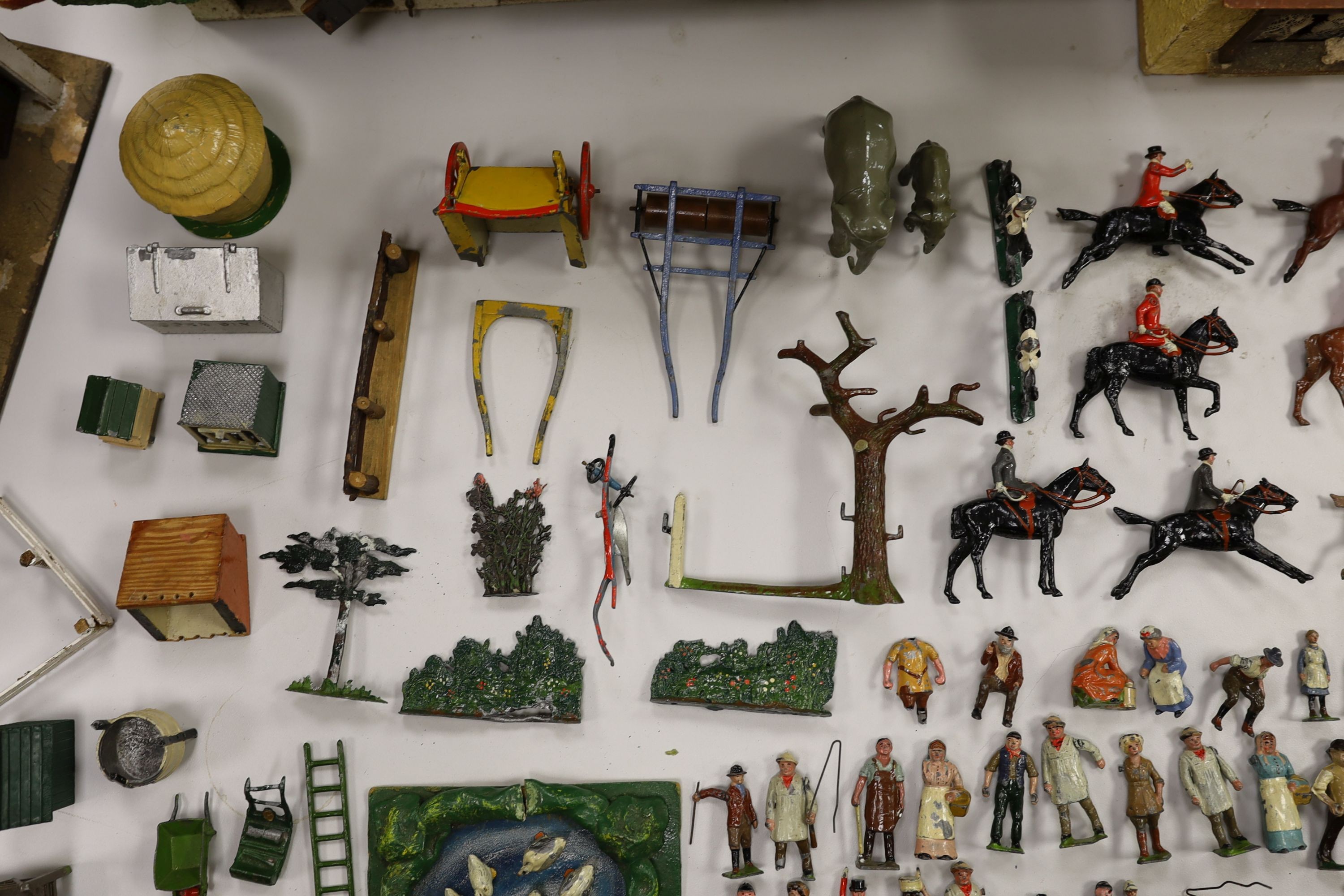 A collection of mainly Britains painted lead figures and animals, including huntsmen and hounds, farm workers, animals and wooden buildings